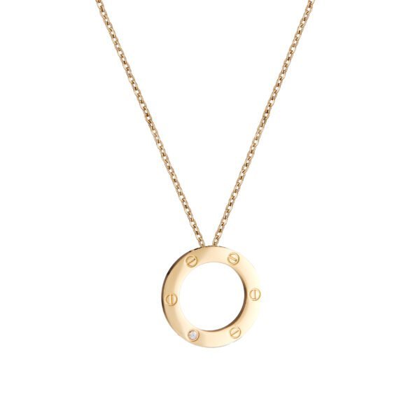 Collier pendentif cercle en or avec détails gravés et pierre brillante.